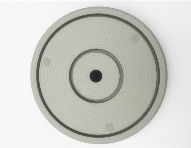 Round metallic component with central hole on a white background